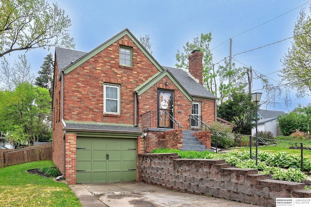 view of front facade featuring fence, roof with shingles, a chimney, brick siding, and an attached garage