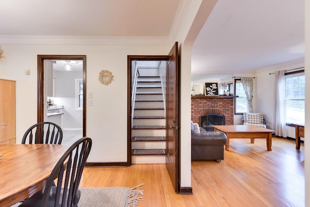 interior space with stairway, baseboards, ornamental molding, and light wood-type flooring