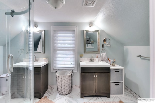 full bath with a sink, two vanities, vaulted ceiling, and a shower stall