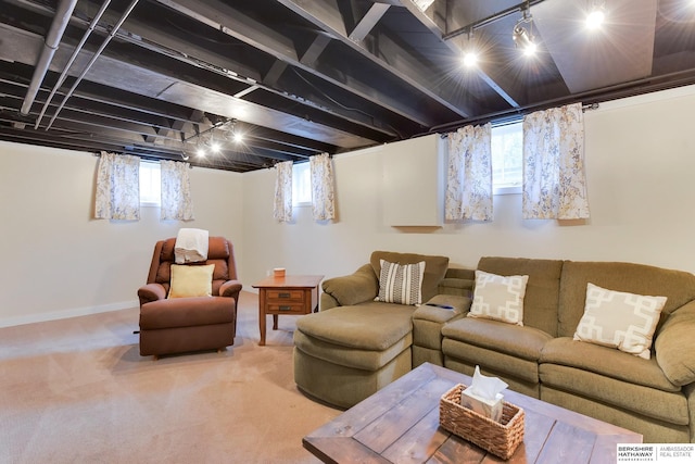 carpeted living area featuring a healthy amount of sunlight and baseboards
