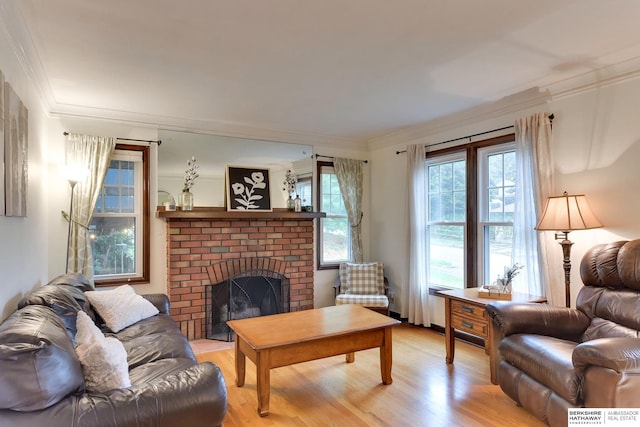 living area with ornamental molding, a fireplace, and light wood finished floors