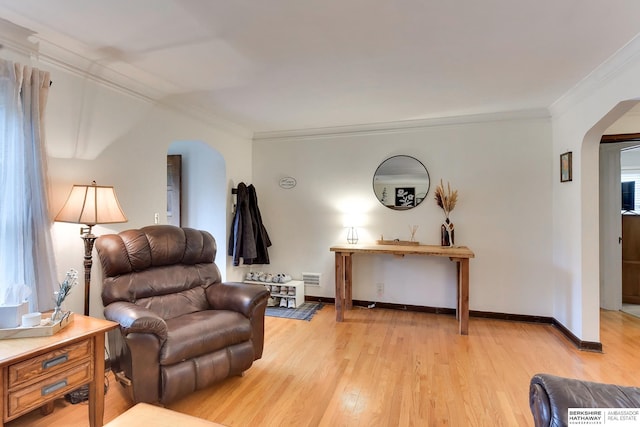 interior space featuring light wood-style floors, arched walkways, and ornamental molding