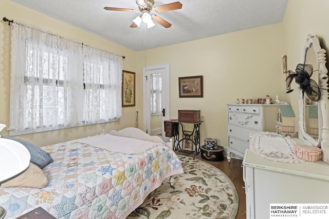 bedroom featuring a ceiling fan, a textured ceiling, and wood finished floors