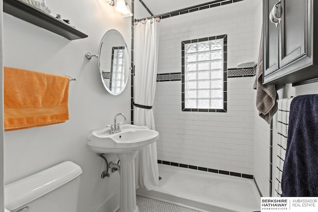 bathroom with a shower stall and toilet