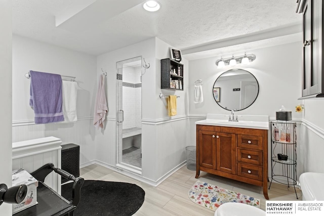 bathroom featuring vanity, wainscoting, and a stall shower