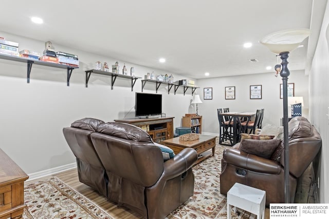 living room featuring recessed lighting, baseboards, visible vents, and light wood-type flooring