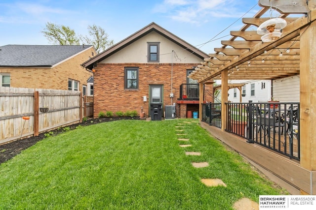 rear view of house featuring a fenced backyard, a pergola, a yard, and brick siding