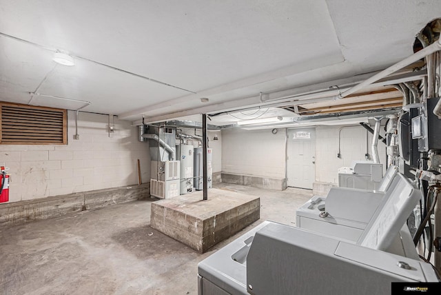 unfinished basement with water heater, separate washer and dryer, heating unit, and concrete block wall