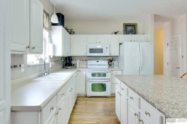 kitchen featuring white appliances, light countertops, white cabinets, a sink, and backsplash