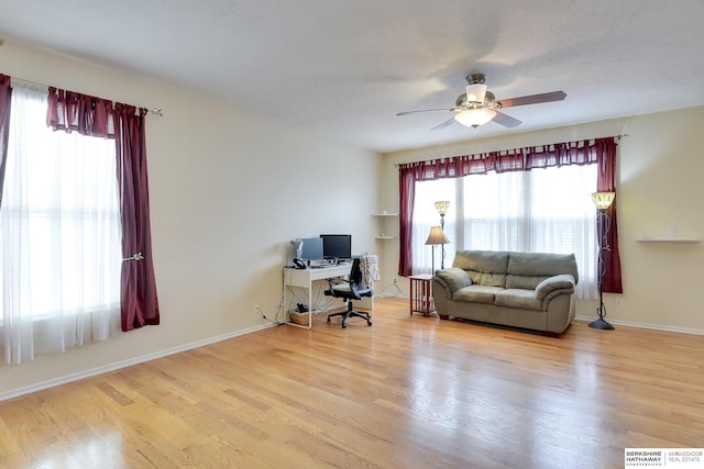 office area with a ceiling fan, baseboards, a wealth of natural light, and wood finished floors