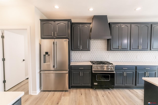kitchen with high quality appliances, light countertops, premium range hood, decorative backsplash, and light wood-type flooring