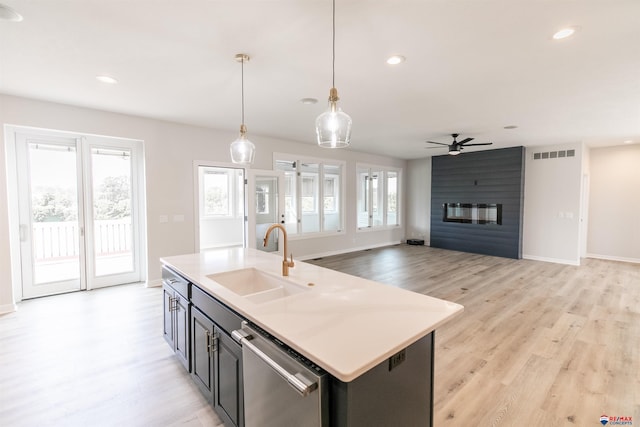 kitchen with ceiling fan, visible vents, a large fireplace, stainless steel dishwasher, and a sink
