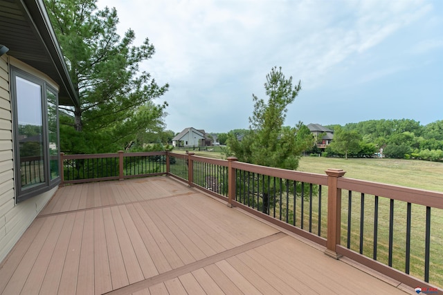 wooden deck featuring a lawn