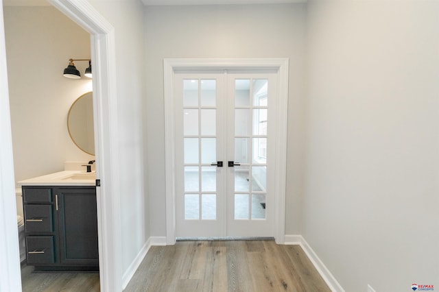 entryway with a sink, plenty of natural light, french doors, and light wood-type flooring