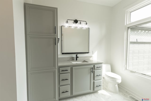 bathroom with visible vents, vanity, marble finish floor, toilet, and baseboards