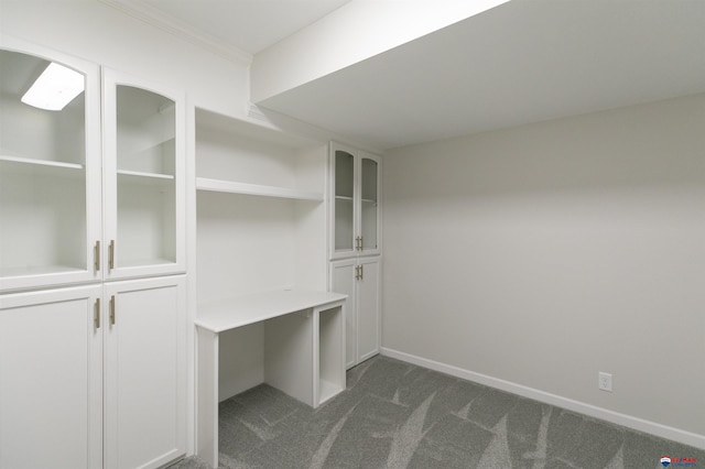 unfurnished office featuring dark colored carpet and baseboards
