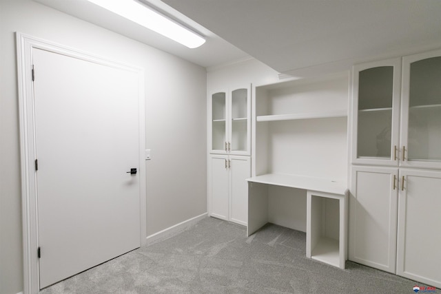 interior space with baseboards and light colored carpet
