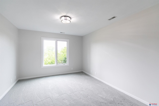 empty room featuring baseboards, visible vents, and carpet
