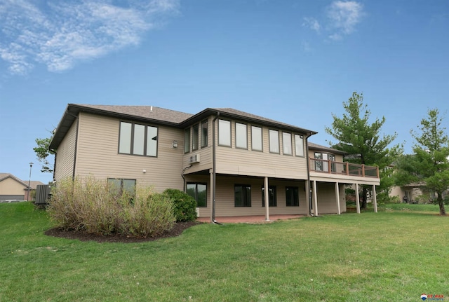 rear view of house featuring a lawn, a wooden deck, and a patio area