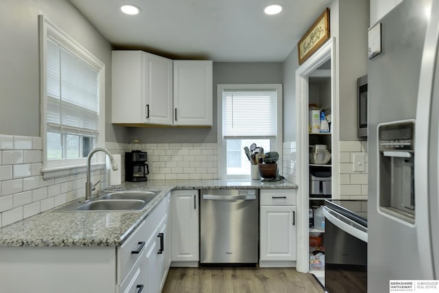 kitchen with light wood-style floors, a sink, plenty of natural light, and stainless steel appliances