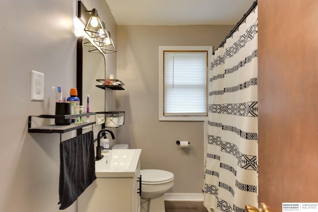 bathroom with toilet, baseboards, curtained shower, and vanity