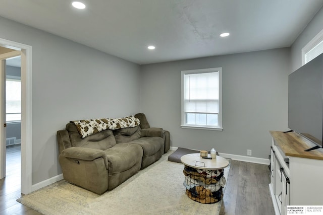 living area with baseboards, recessed lighting, and wood finished floors