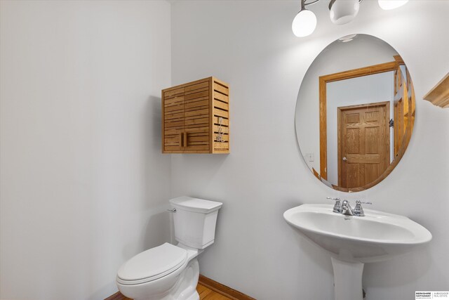 11380 24th Ave, Plattsmouth, NE 68048 - bathroom featuring baseboards, a sink, wood finished floors, and toilet