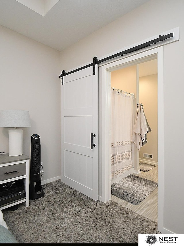 interior space featuring baseboards, a barn door, and visible vents