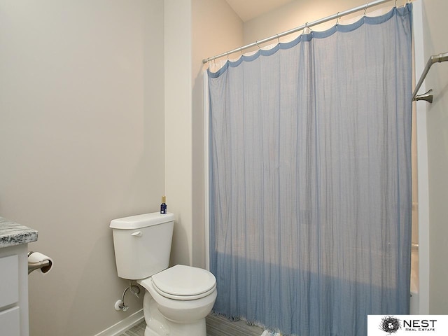 full bathroom featuring baseboards, toilet, and a shower with shower curtain
