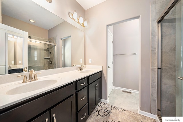 full bath with double vanity, visible vents, a shower stall, and a sink
