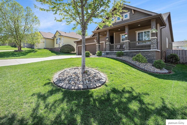 view of front of property featuring fence, a front lawn, stone siding, covered porch, and driveway