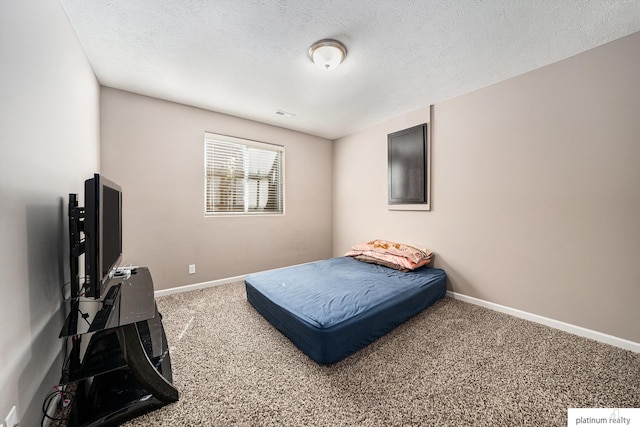 carpeted bedroom featuring baseboards and a textured ceiling