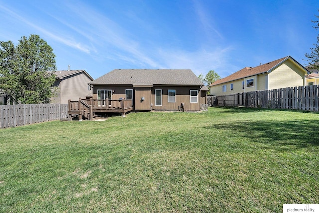 back of property featuring a lawn, a deck, and a fenced backyard