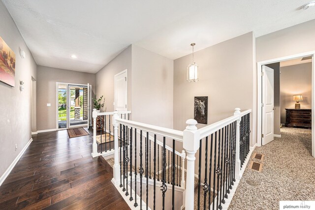 hall with recessed lighting, baseboards, an upstairs landing, and hardwood / wood-style floors
