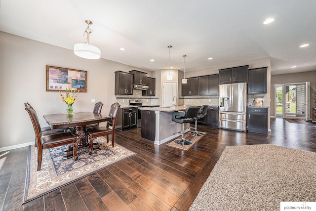 dining room with dark wood-style flooring, baseboards, and recessed lighting
