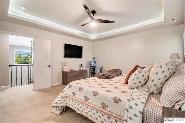 bedroom with a raised ceiling, baseboards, carpet flooring, and visible vents