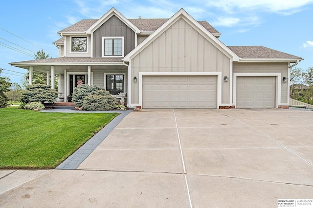 view of front of property featuring covered porch, a front yard, board and batten siding, an attached garage, and driveway
