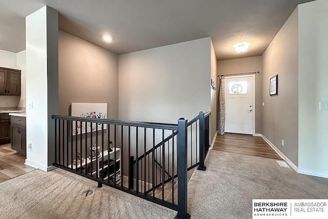 entrance foyer with baseboards and carpet