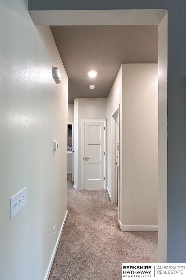 hall with baseboards and carpet flooring