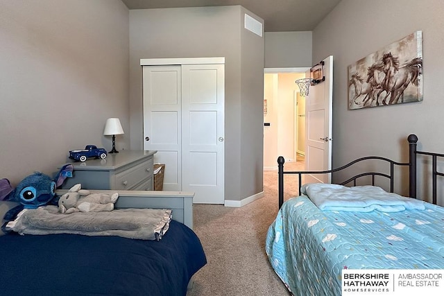 bedroom with baseboards, visible vents, a closet, and light colored carpet