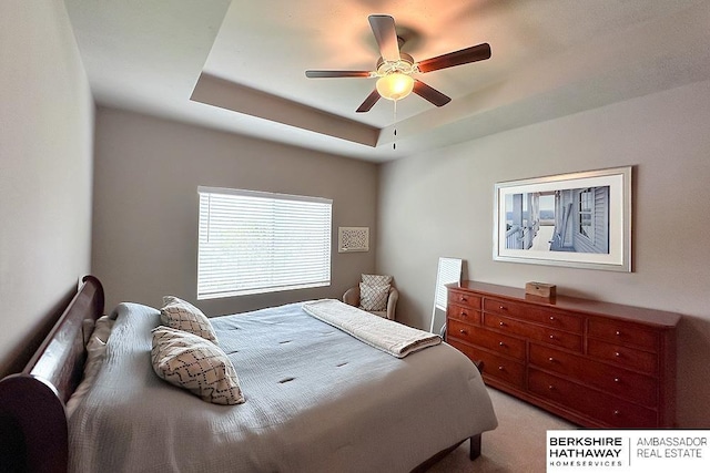 bedroom with carpet, a raised ceiling, and ceiling fan