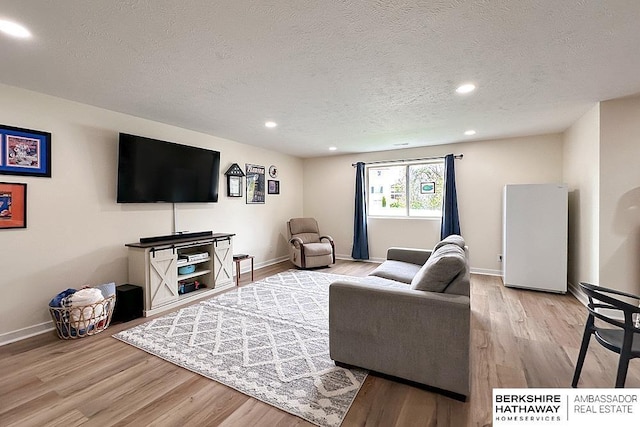 living area with a textured ceiling, baseboards, recessed lighting, and wood finished floors