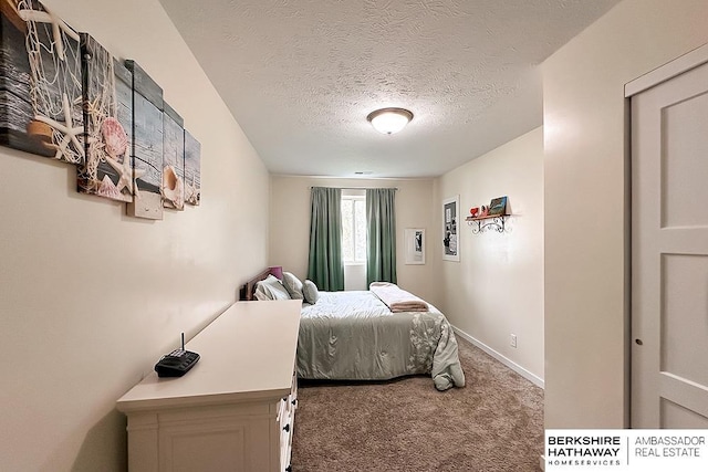 carpeted bedroom with baseboards and a textured ceiling