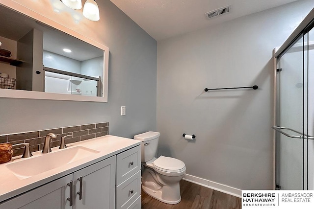 bathroom with visible vents, wood finished floors, baseboards, tasteful backsplash, and a stall shower