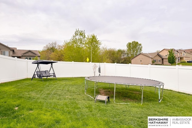 view of yard featuring a fenced backyard and a trampoline