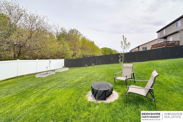 view of yard with a fenced backyard and a fire pit