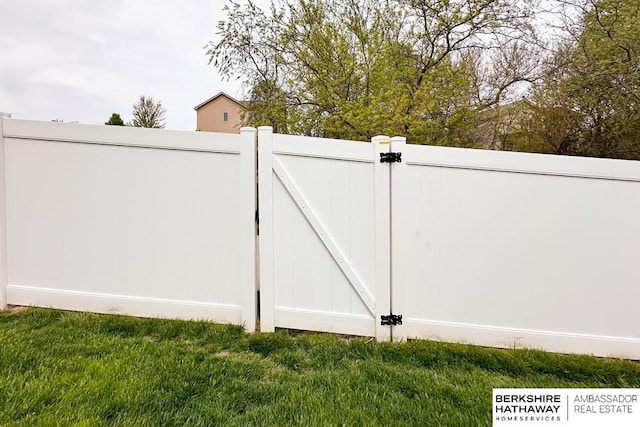 view of gate with a lawn