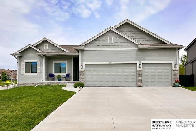 craftsman house featuring an attached garage, driveway, stone siding, and a front yard