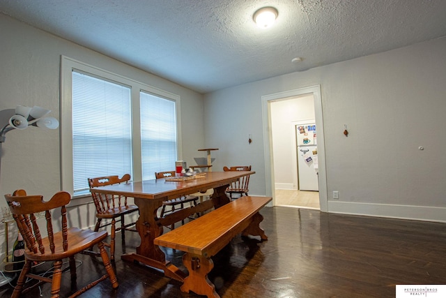 dining space with baseboards, a textured ceiling, and wood finished floors