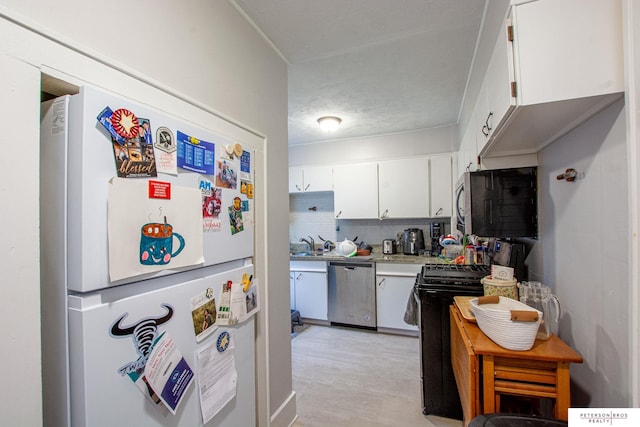 kitchen featuring backsplash, appliances with stainless steel finishes, light countertops, a sink, and white cabinets